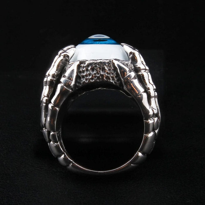A top-down view of the blue eyeball ring, showing the vivid iris and the sharp claws encircling the eye.