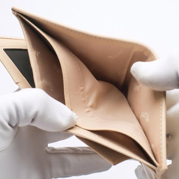 Close-up of the beige leather interior lining and spacious bill compartment of a luxury crocodile skin wallet.