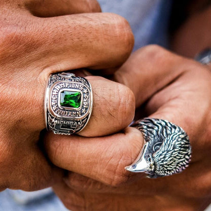 A man's hand wearing the large green Michigan State championship ring.