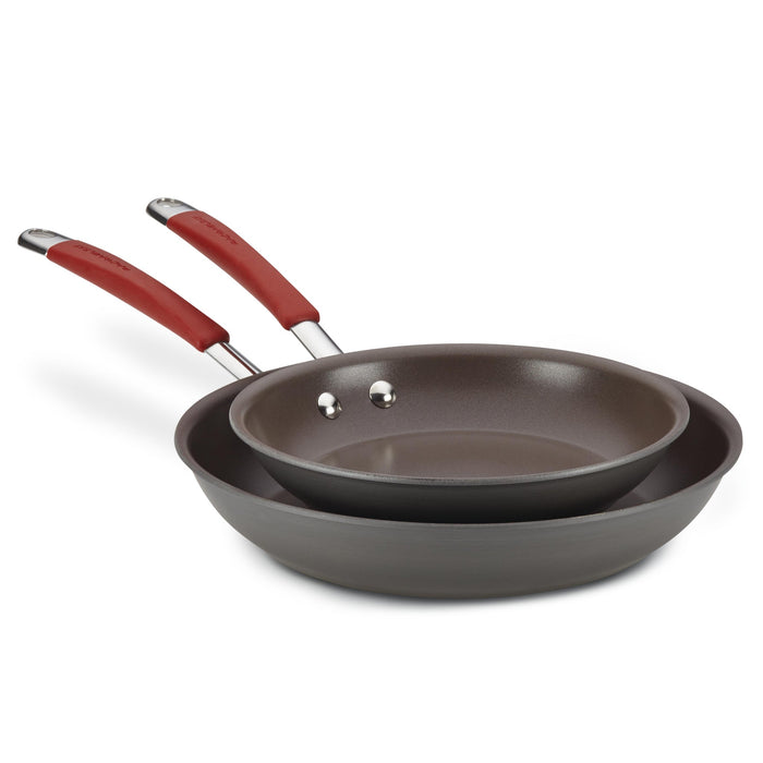 The 9.25" and 11.5" Cucina Hard Anodized Nonstick Frying Pan Set features two frying pans with oven-safe red handles, stacked on top of each other.