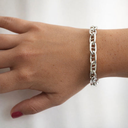 Kvinna som bär ett armband med silverkedja - modell bred Ankarkedja.