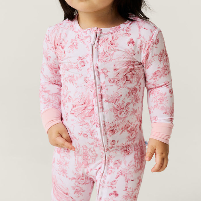 Child wearing a pink floral one piece against a neutral background