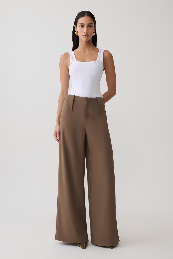 Woman wearing white tank with brown  wide leg suiting trouser.