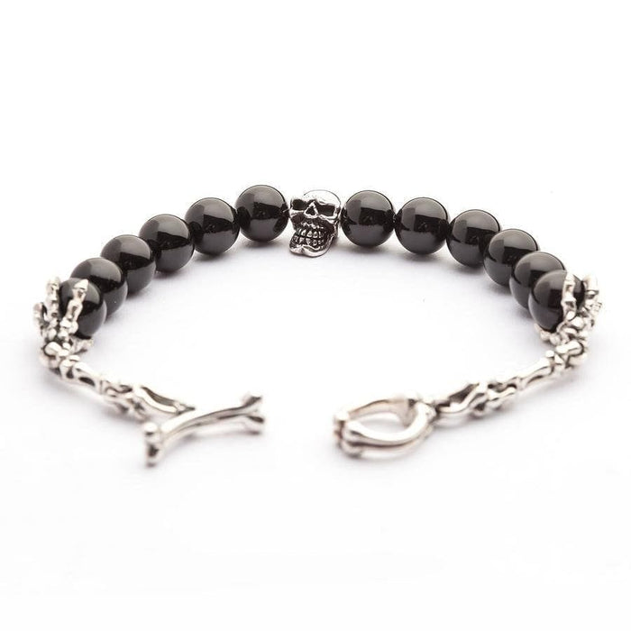 The full black onyx skull bracelet laid flat with its skeleton hand and bone clasp open, showing the complete design.