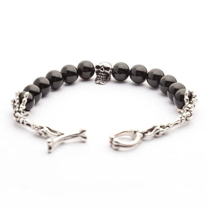 The full black onyx skull bracelet laid flat with its skeleton hand and bone clasp open, showing the complete design.