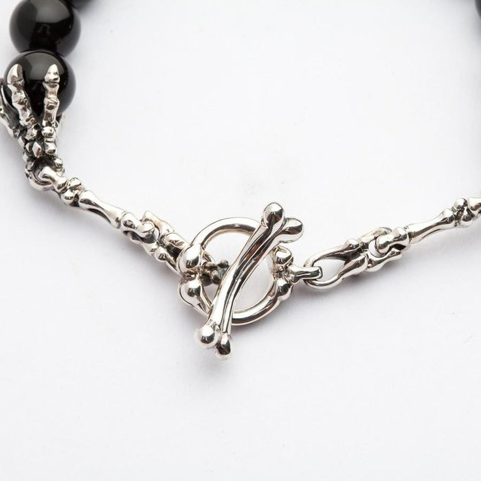 Detailed studio shot of the 925 sterling silver bone toggle clasp and skeleton hand craftsmanship.