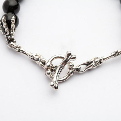 Detailed studio shot of the 925 sterling silver bone toggle clasp and skeleton hand craftsmanship.