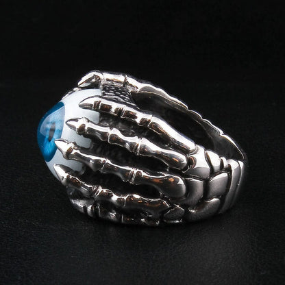 A close-up detail shot of the realistic eyeball ring, focusing on the sharp talons of the silver claw gripping the eye.