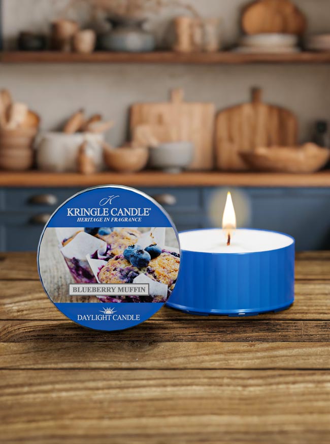 Kringle Candle blueberry muffin candle on a wooden surface with a kitchen background
