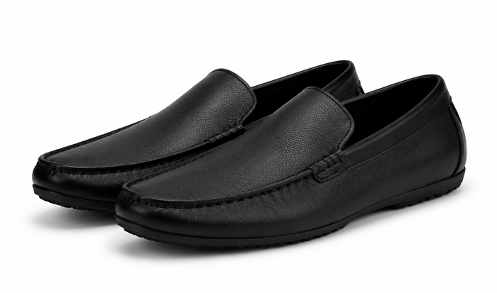 Pair of black leather loafers on a white background