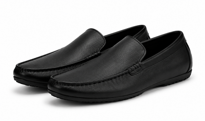 Pair of black leather loafers on a white background