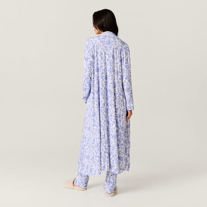 Woman wearing a long floral robe on a plain background