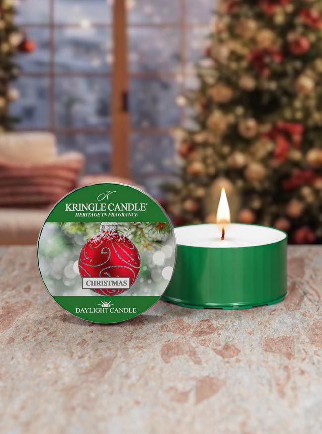 Kringle Candle Christmas scented candle with packaging in front of a decorated Christmas tree.
