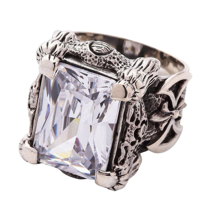A close-up of the silver dragon talon ring, detailing the four powerful claws gripping the large, clear emerald-cut stone.