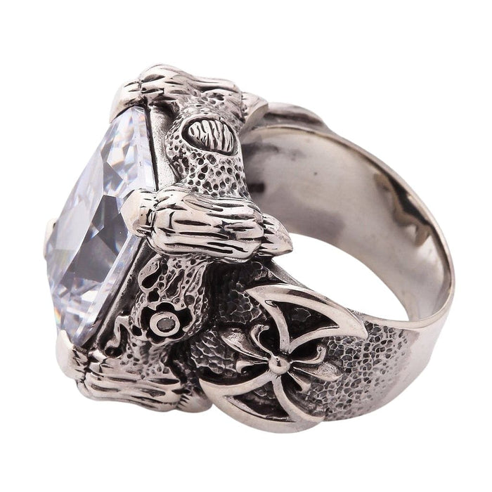 The large clear stone ring in a gothic style, showing the double-axe warrior detail on the textured band.