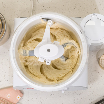 Bosch white universal plus mixer with NutriMill bowl scraper and pro line cookie paddles with metal whip drive on white speckled counter