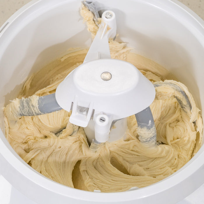 NutriMill bowl scraper and pro line cookie paddles with metal whip drive mixing white dough in white bowl