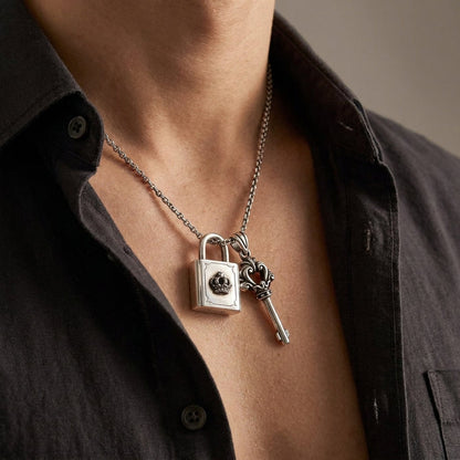 A close-up of a male model wearing a lock and key pendant featuring a detailed padlock and key charm under soft studio lighting.