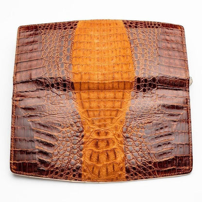 Flat lay of unfolded crocodile leather wallet exterior displaying golden tan dorsal ridge centered between dark brown flanks with natural scale gradation