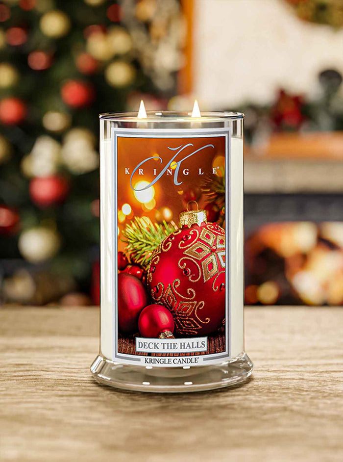 Kringle Candle with Christmas design on a wooden surface with blurred festive background