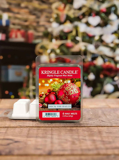 Kringle Candle wax melt package on a wooden surface with a Christmas tree in the background