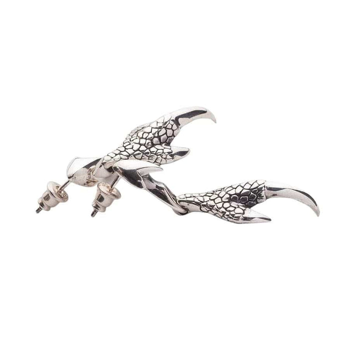 Flat lay of dragon claw drop earrings showing scale pattern and polished talons