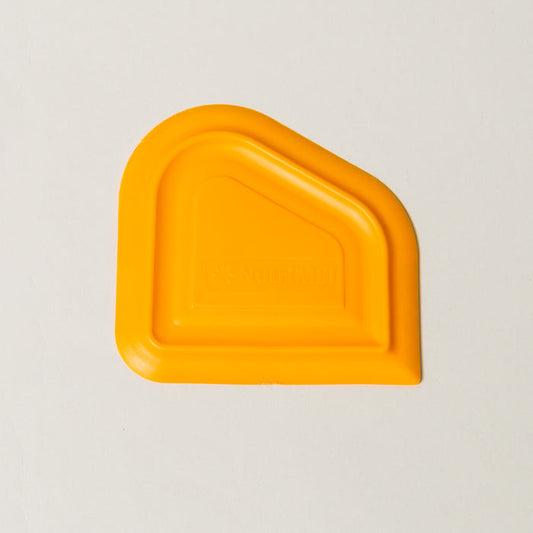NutriMill orange easy scrape bowl scraper on a white background