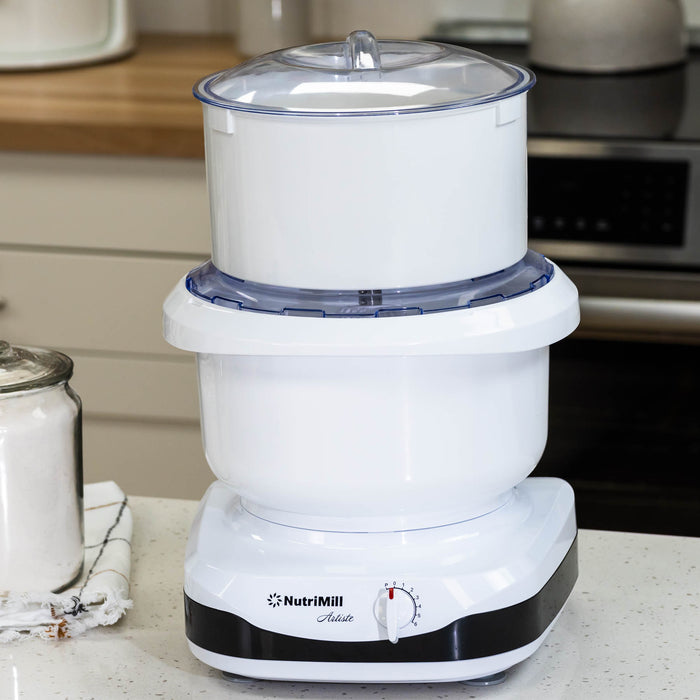 NutriMill Artiste mixer with a flour sifter attached on a white kitchen counter