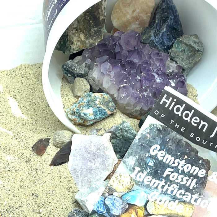 Gemstone Mining Surprise Bucket  after opening, with sand on white, up close view