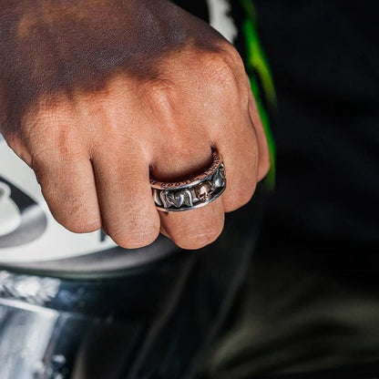 A man wearing the gothic skull spinner ring on his middle finger.