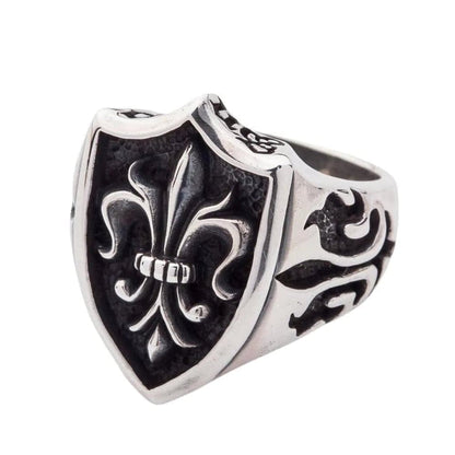 An angled side view of the gothic fleur de lis ring, showing the band's medieval carvings.