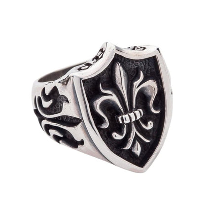 close-up of the fleur de lis shield ring, highlighting the oxidized, textured background.