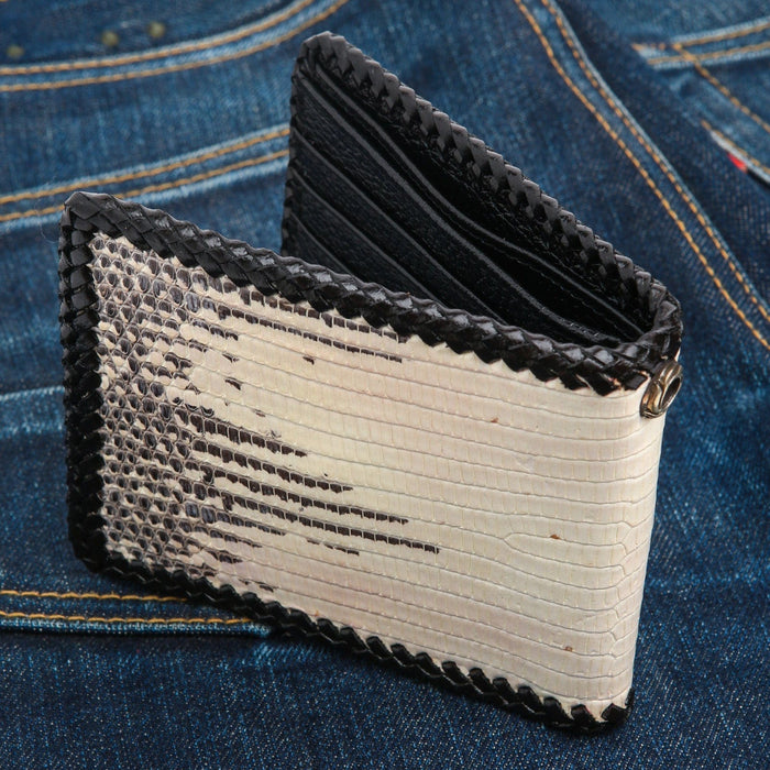 Cream and dark scales across the bifold, black whipstitching at the edge and a metal eyelet on the spine.
