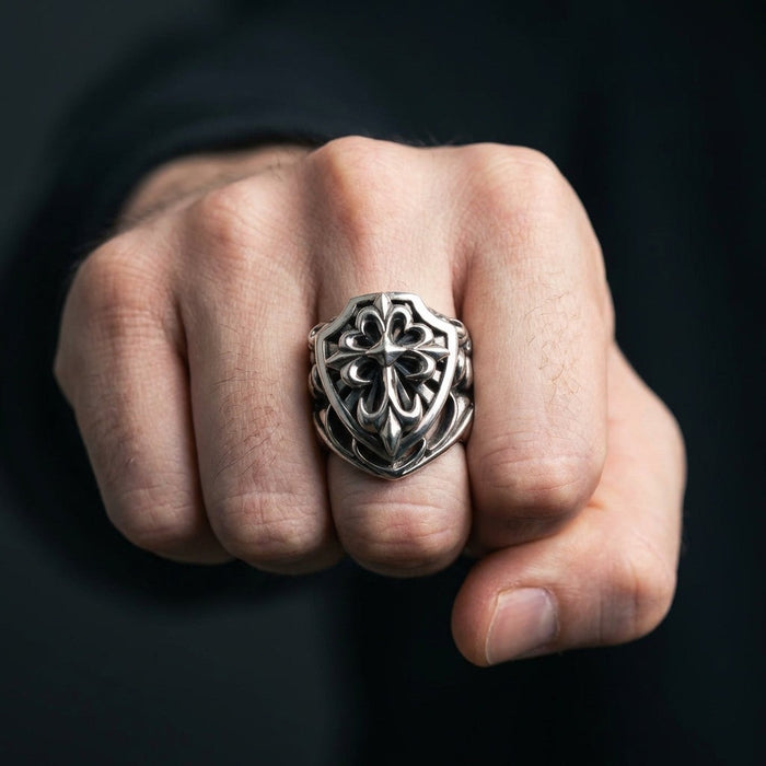 Man wearing 40-gram sterling silver shield of faith gothic cross ring on middle finger with clenched fist