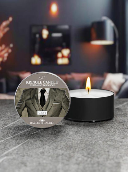 Kringle Candle daylight candle with a label featuring a suit on a gray surface.