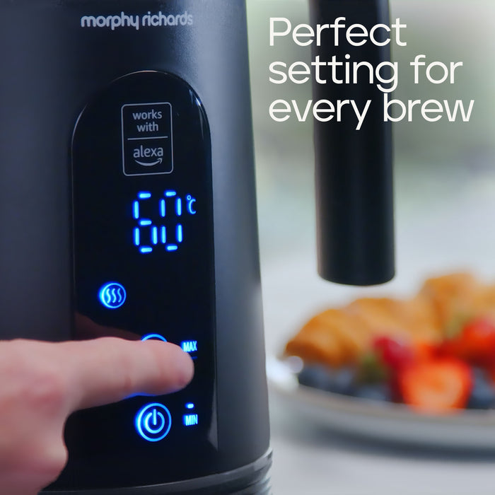 A close-up of a black Morphy Richards coffee maker with a finger pressing the display, showing blue LED numbers and settings. A plate of pastries and fruit is blurred in the background, and white text on the right reads 'Perfect setting for every brew'.