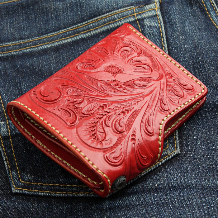 A close-up detail of the durable metal grommet used for attaching a wallet chain to the red leather wallet.