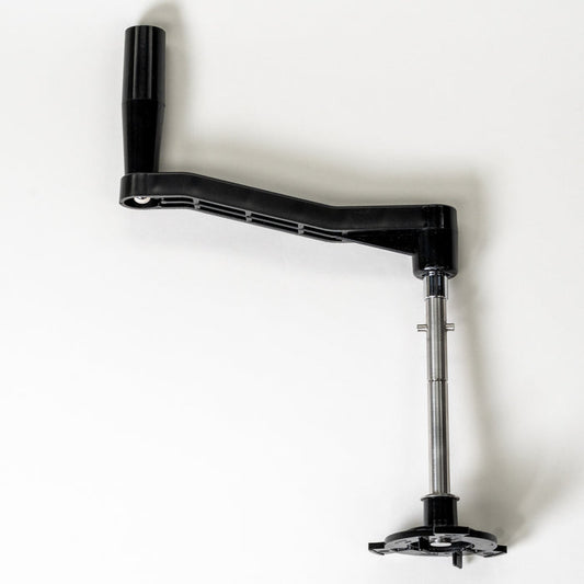 Black and silver hand crank for Bosch mixer laying on grey background