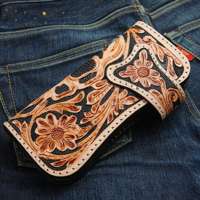 Tan carving over a pebbled black ground, thick white stitching following the two-tone panel and strap.