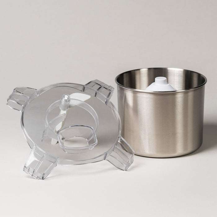 White ice cream maker shown disassembled with its clear lid, paddle, and stainless steel bowl on a white background