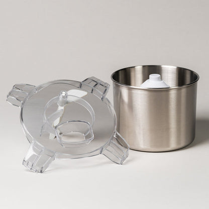 White ice cream maker shown disassembled with its clear lid, paddle, and stainless steel bowl on a white background
