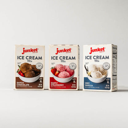 Three boxes of Junket ice cream mix. From left to right: Dutch Chocolate, Simply Strawberry, and Very Vanilla flavors on a grey background