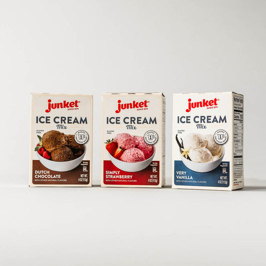 Three boxes of Junket ice cream mix. From left to right: Dutch Chocolate, Simply Strawberry, and Very Vanilla flavors on a grey background