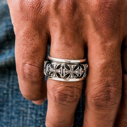 A man's hand wearing the solid sterling silver iron cross spinner ring.