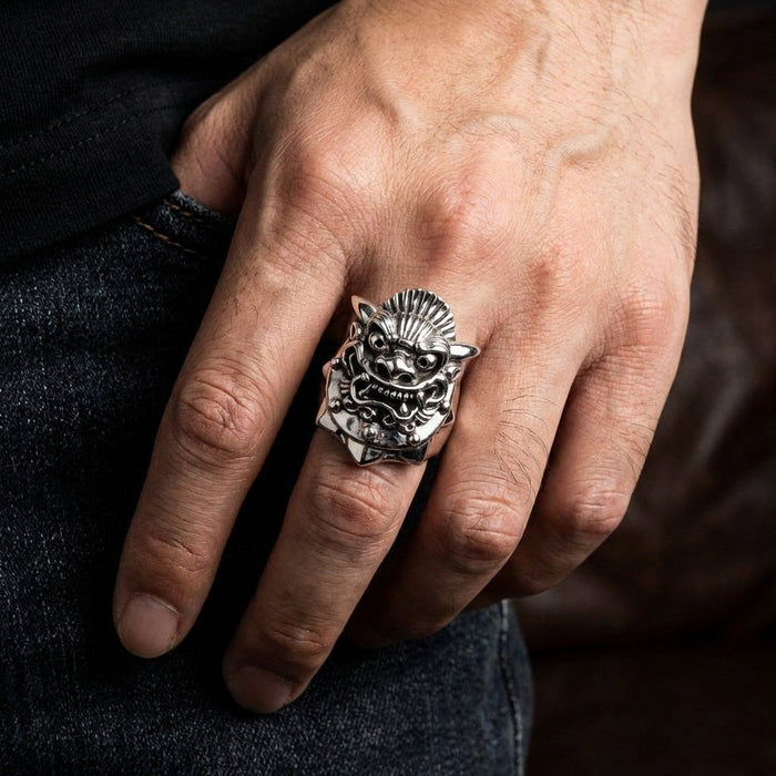 Man wearing heavy sterling silver Hannya mask ring on middle finger, showcasing oxidized horned demon face against dark denim