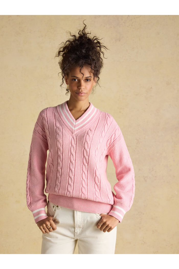Model wearing Joules W25282 Dibly Cable Knit Jumper – Pink featuring cable knit pattern and striped V-neck by Joules. Shop Joules at Dotique.