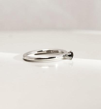 Silverring med svart diamant, sedd från sidan. Diamanten är infattad i krona.