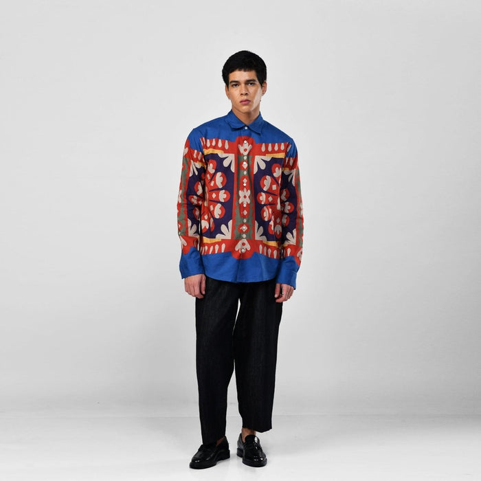 Man wearing the blue Kanaat shirt with black trousers, full length front view, arms at his sides