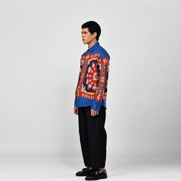 Man wearing the blue Kanaat shirt with black trousers, full length side view
