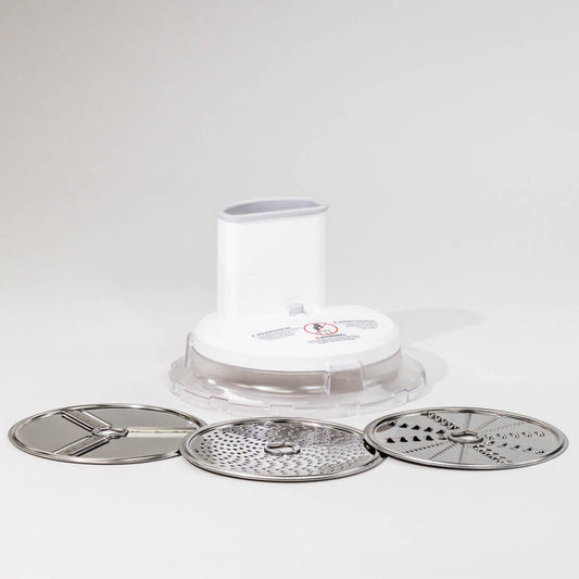 A white food slicer shredder attachment with three interchangeable stainless steel blades, displayed on a light background.